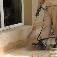 General pest control technician spraying exterior perimeter around a home in Columbia, MO